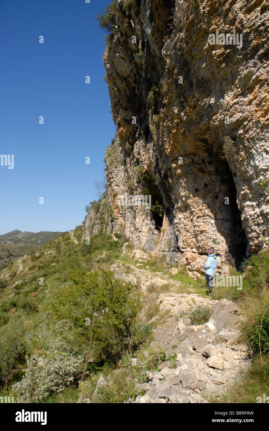 woman hiker exploring caves off Mozarabic trail, Vall de Laguart, Benimaurell, Alicante Province, Comunidad Valenciana, Spain Stock Photo