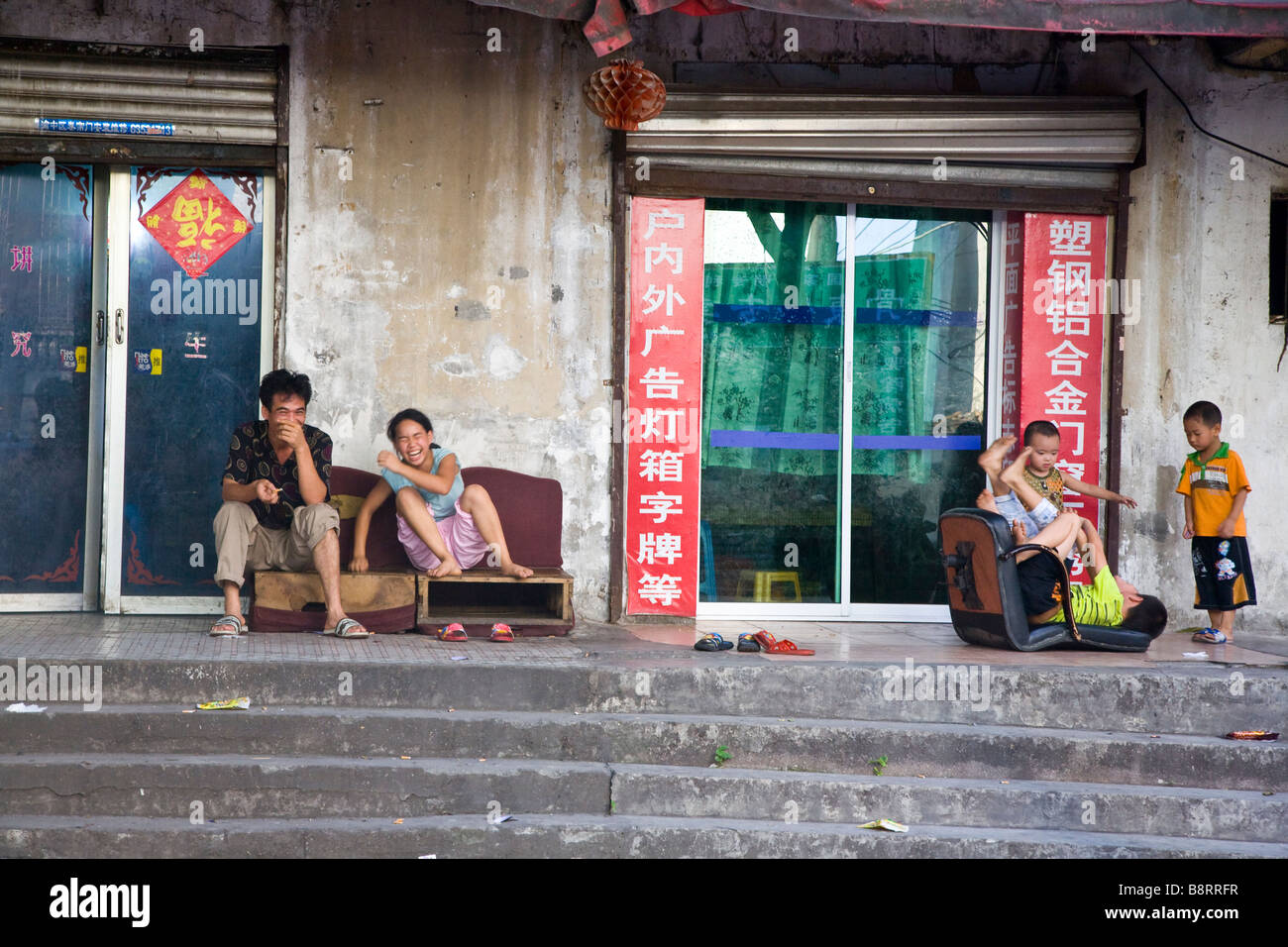 Chinese family having fun in front of their shop in the old part of Chongqing, southwestern China. Stock Photo