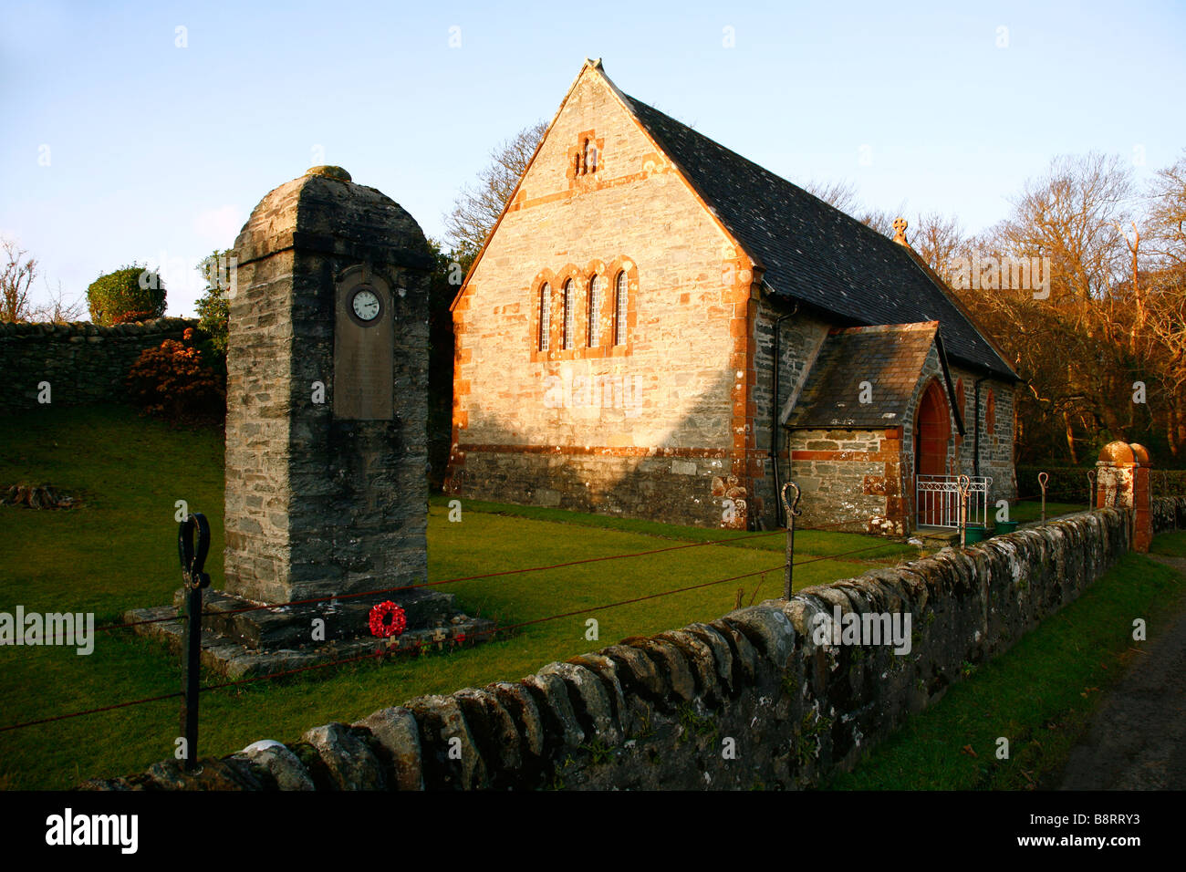 The small parish church at Skipness on the Kintyre Peninsular showing the unusual war memorial with the inset clock.Scotland,UK. Stock Photo