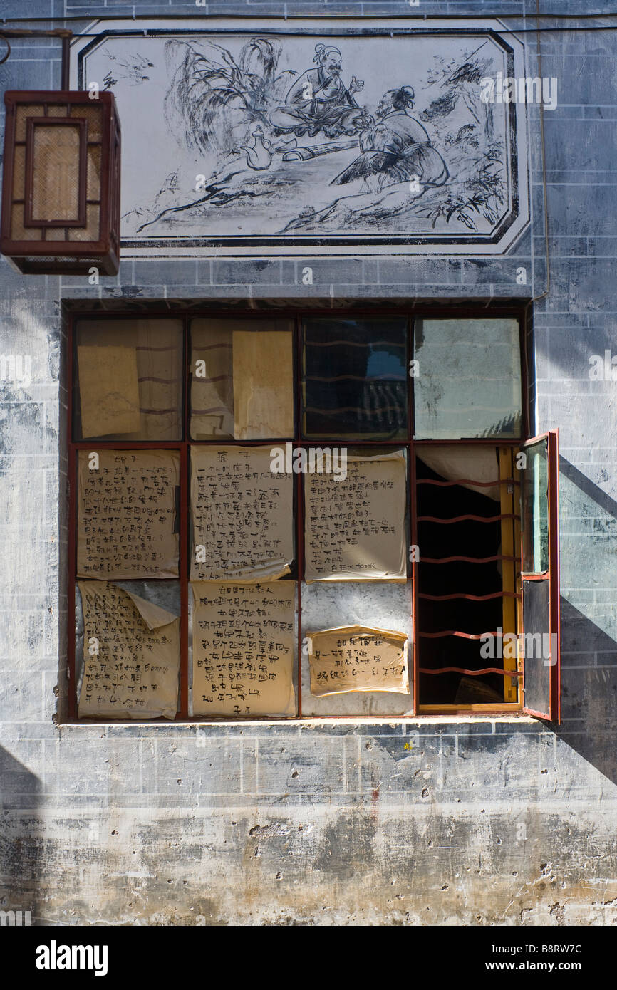 Chinese manuscripts an paintings on a facade in the village of Lijiang, Yunnan province, China. Stock Photo