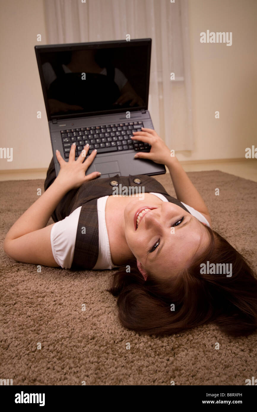 Woman with laptop on carpet Stock Photo Alamy