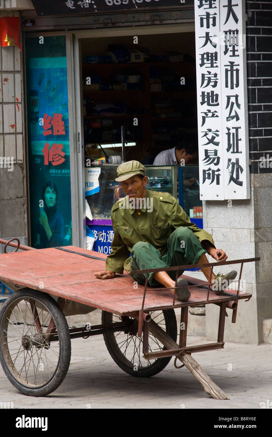 A chinese soldier relaxing on a cart in Dali, Yunnan province, China. Stock Photo