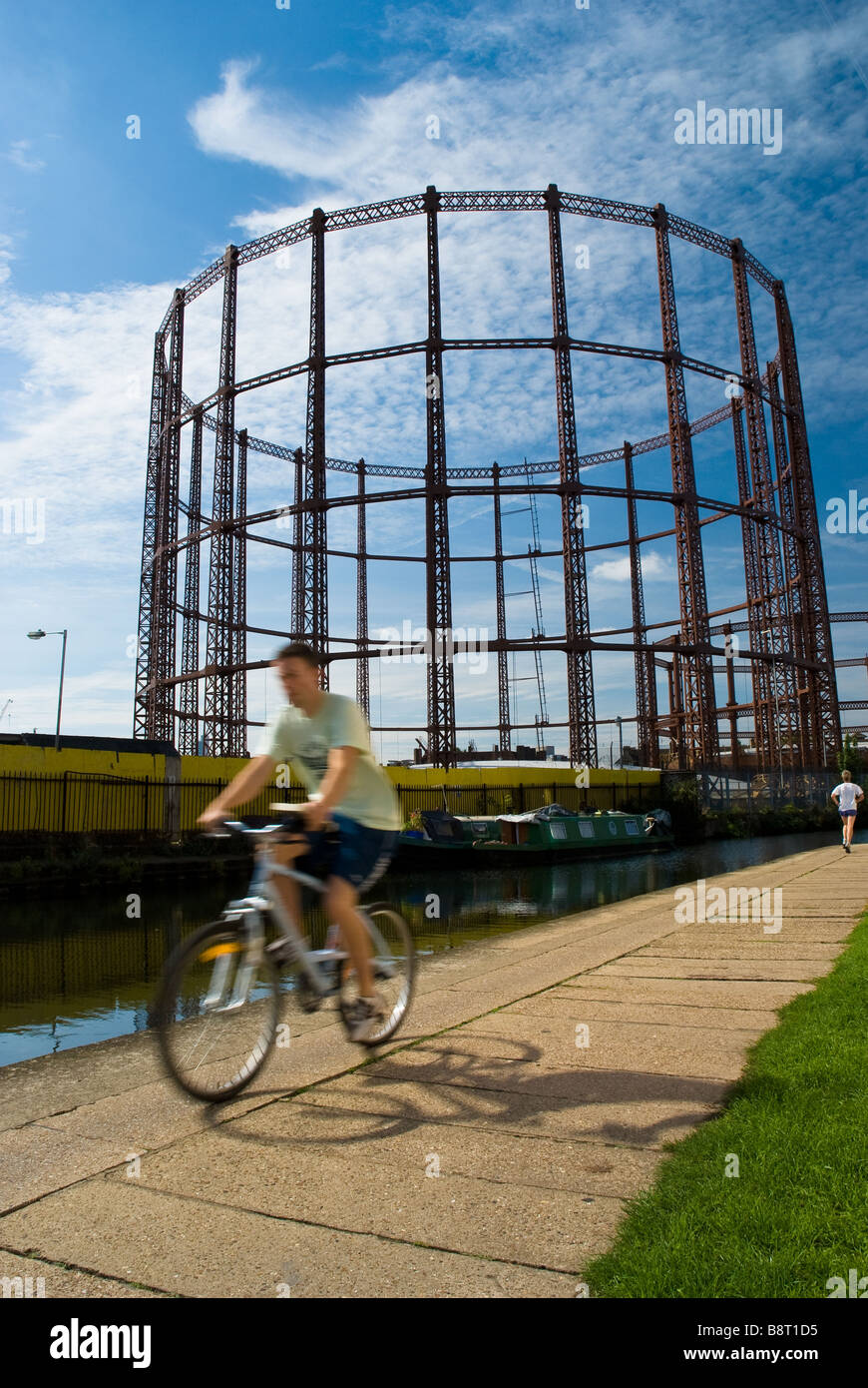 A cyclist rides his bike along the Regent Canal near Mile End and Victoria Park in east London, England. Stock Photo