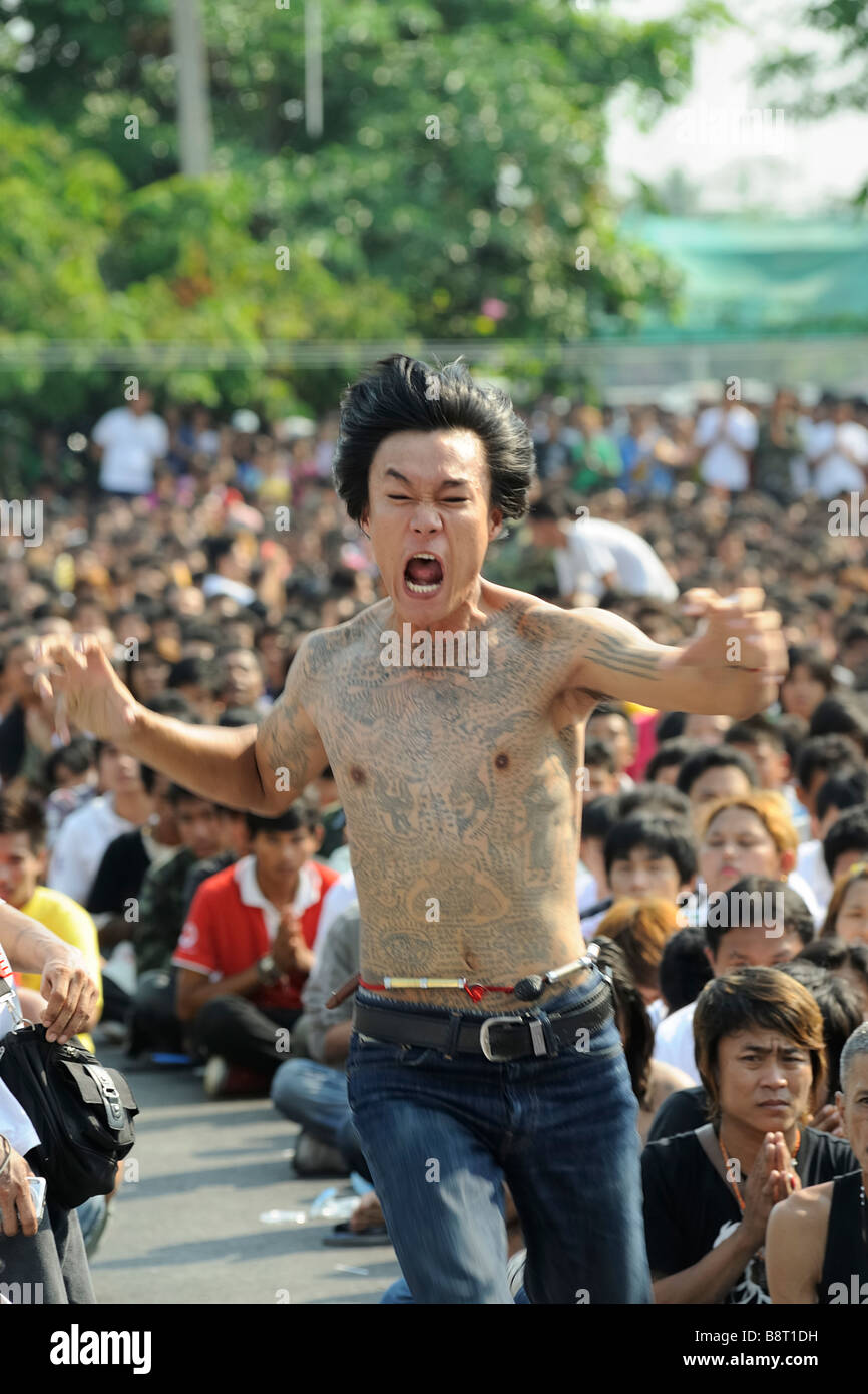 Tattoo festival at Wat Bang Phra temple, Nakhon Chai Si, Thailand. Man becomes possessed with spirit of his tattoos. Stock Photo