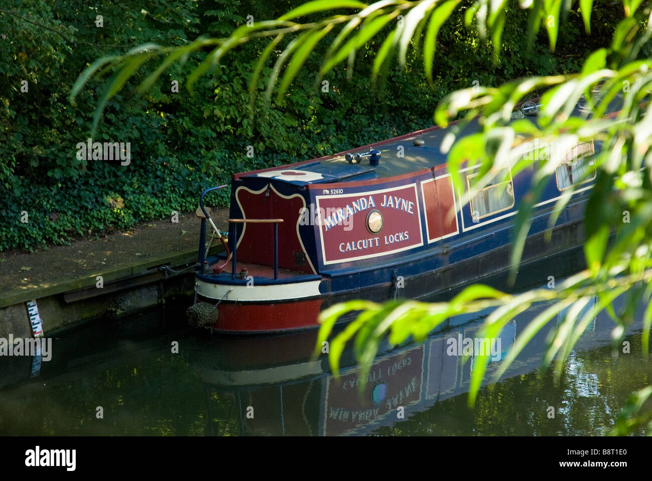 A narrow boat, also known as a house boat, is moored by the side of the Regent Canal in London, UK. Stock Photo