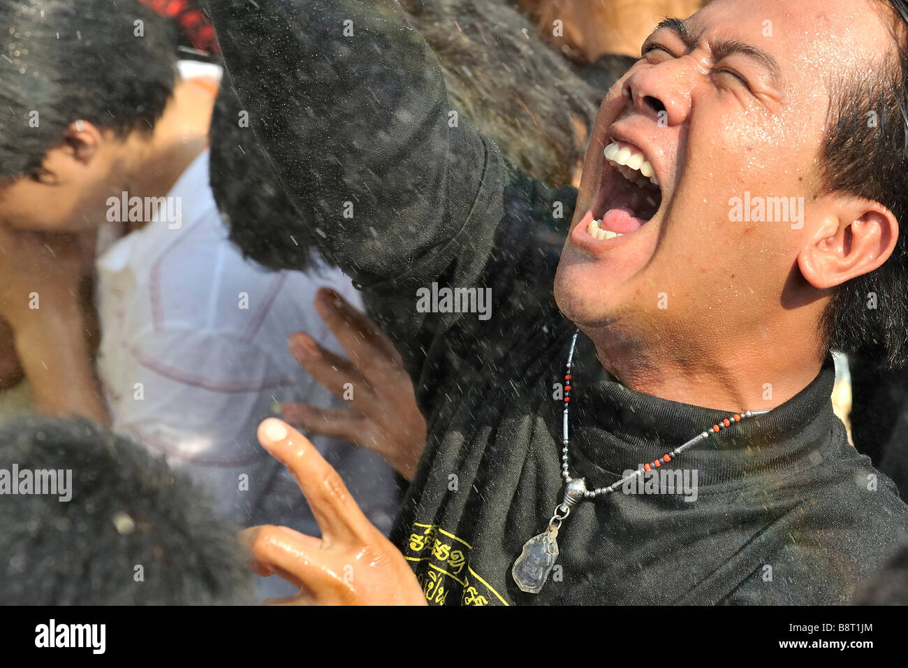 Devotees receiving holy water at tattoo festival at Wat Bang Phra temple, Nakhon Chaisi, Thailand. Stock Photo