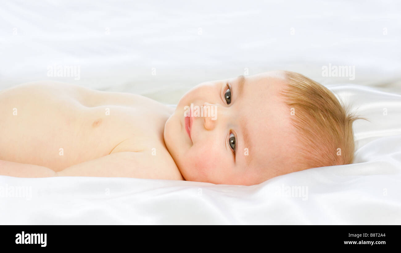 tranquil-baby-boy-on-white-satin-stock-photo-alamy