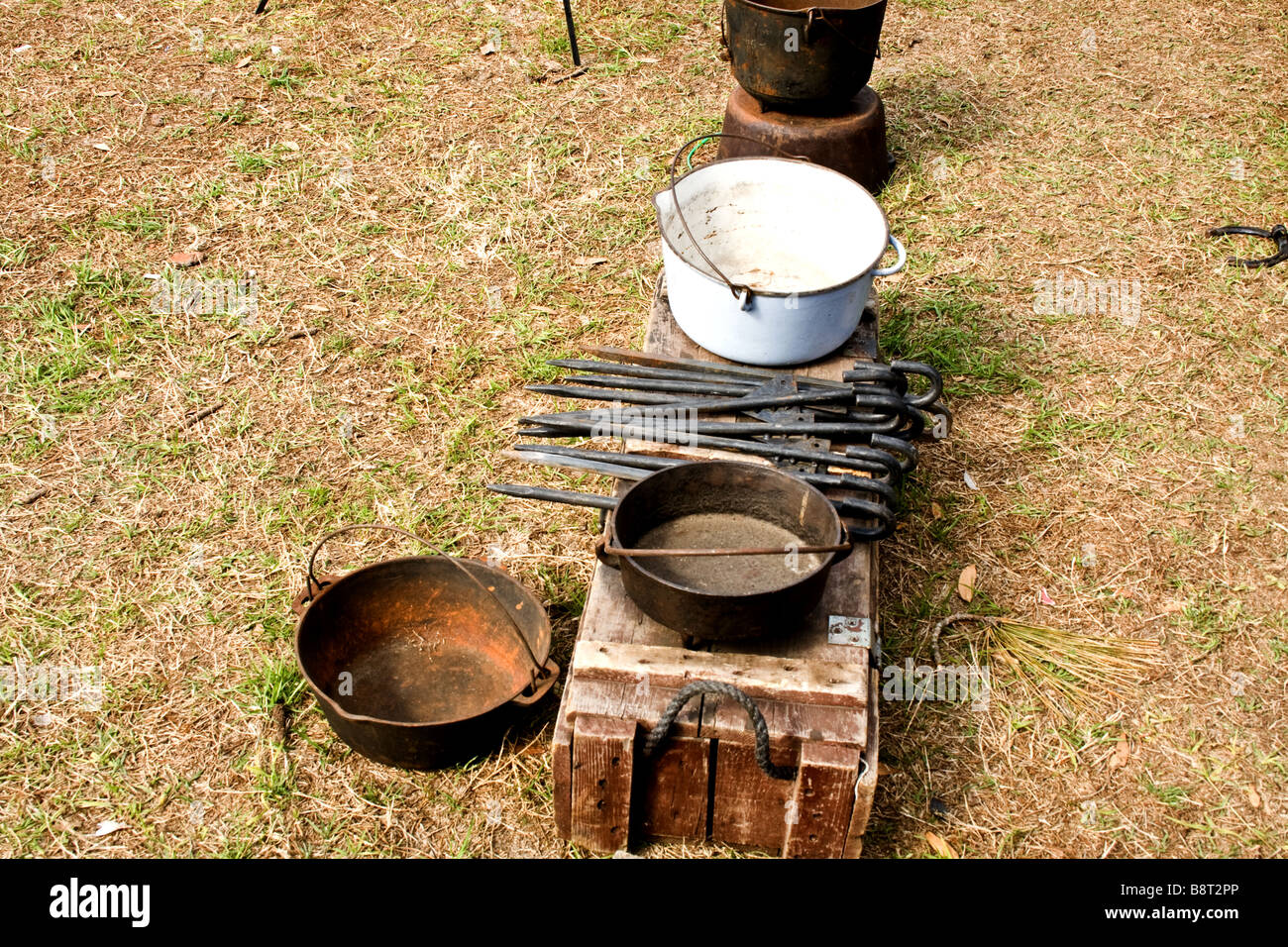 Old fashion cooking utensils and metal spikes on a wooden bench Stock Photo