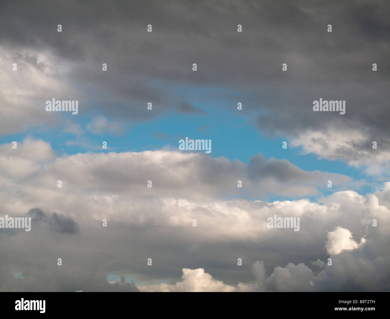 Blue sky emerging from grey storm clouds Stock Photo - Alamy