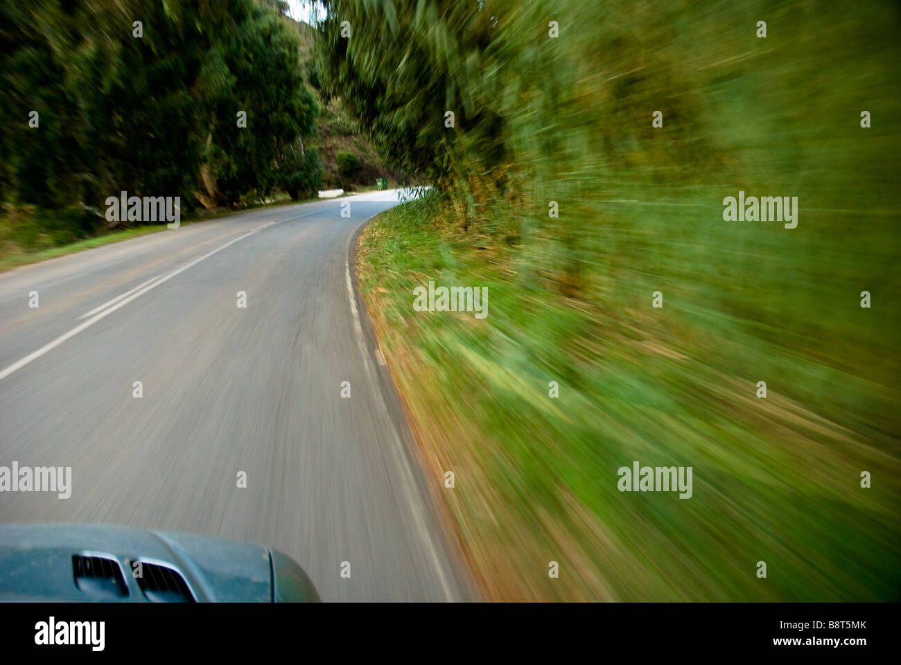 A car speeding  along a road in Costa Vicentina National Park in The Algarve region of Portugal. Stock Photo