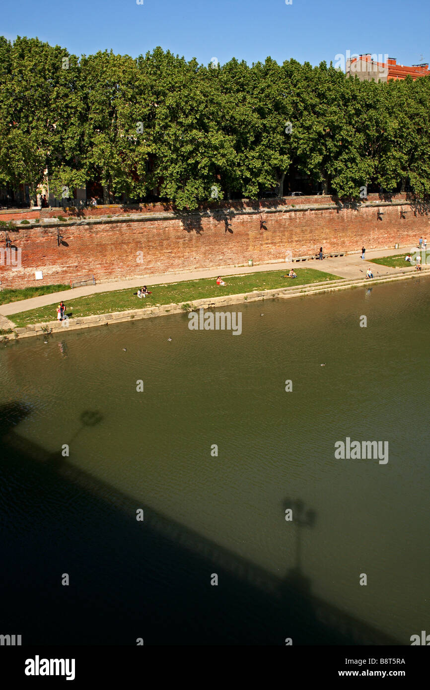 A view from the Saint Pierre bridge of people relaxing along the banks of the Garonne River in Toulouse, France. Stock Photo