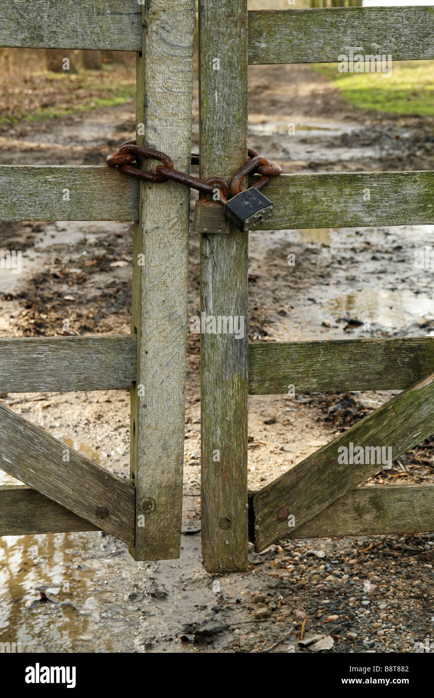 Locked gates, wooden gate, secured, rusty padlock, chain, farm track