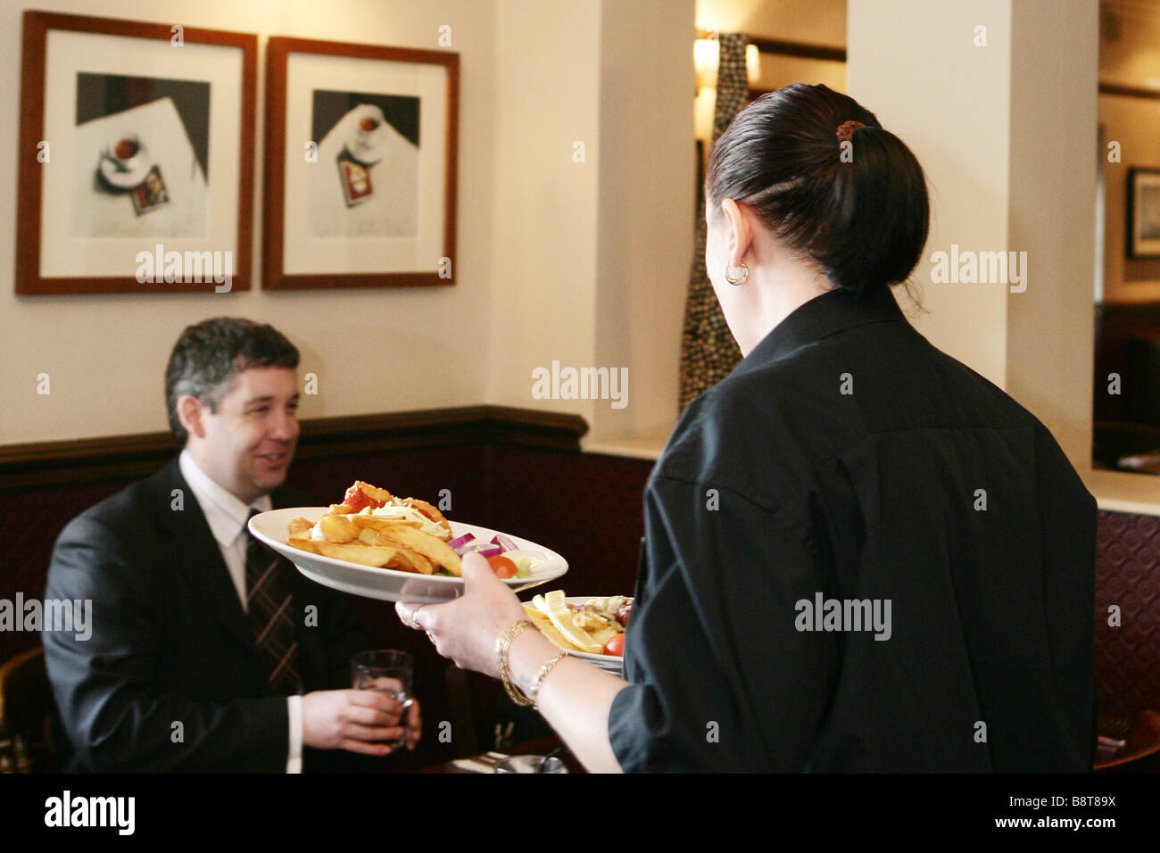 Waitress Serving Food In Bar Stock Photo Alamy