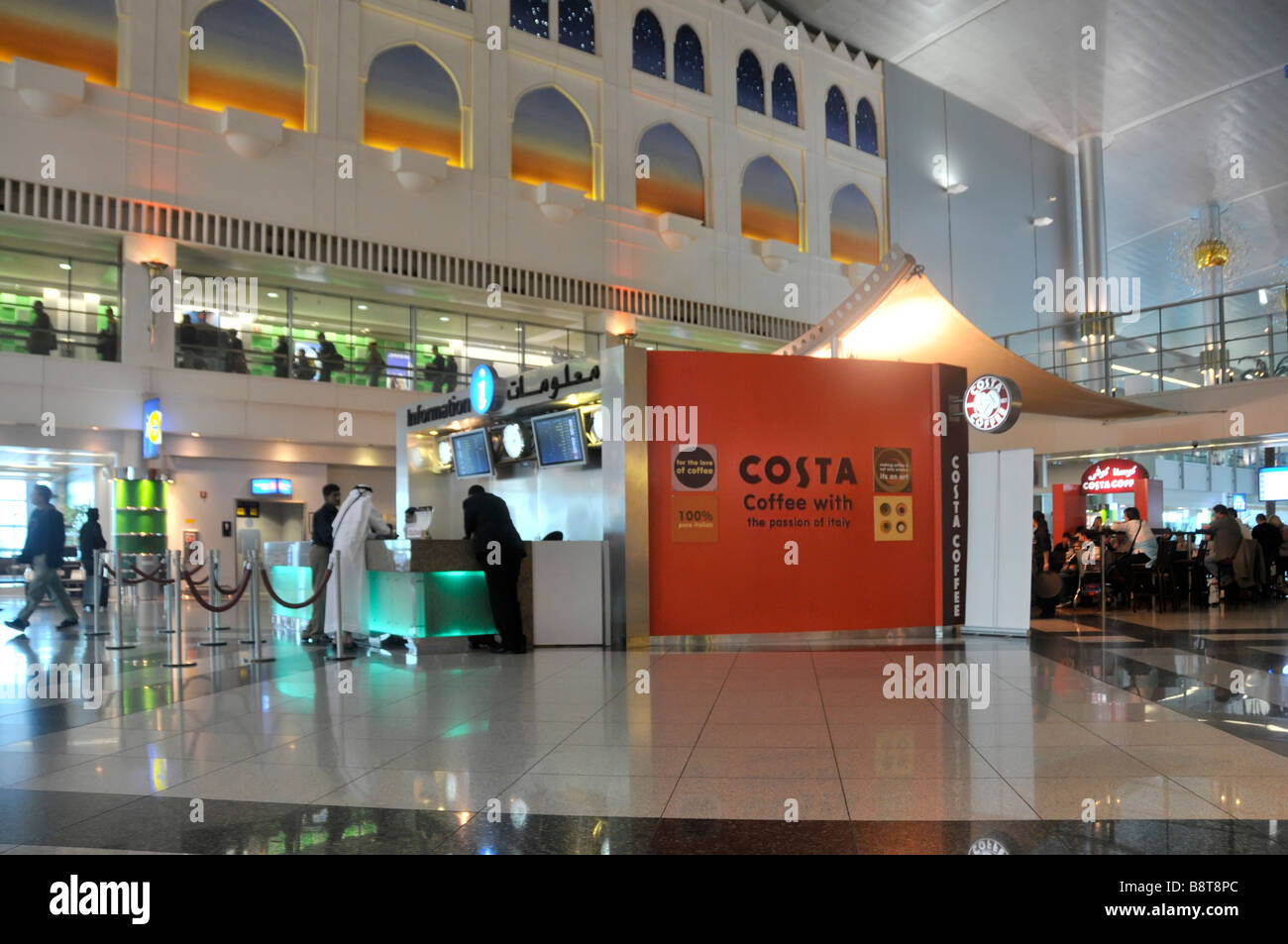 Dubai international passengers airport interior departure lounge & travel information desk people at Costa coffee shop United Arab Emirates UAE Asia Stock Photo