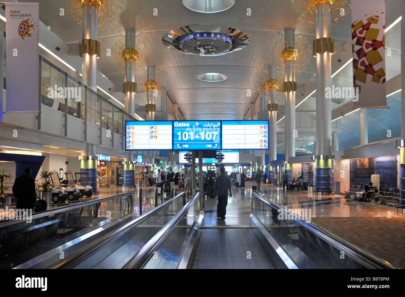 Dubai international airport passengers in modern interior departure lounge building moving pavements travellator United Arab Emirates UAE Middle East Stock Photo
