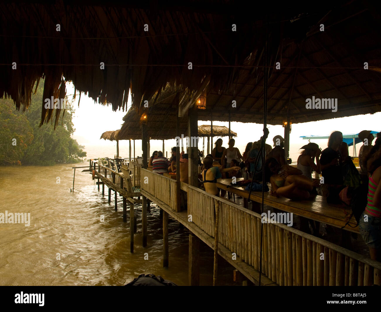Brazilian weekend partiers take refuge on a stilt house bar on the Guama river in Belem do Para, during a summer afternoon storm Stock Photo