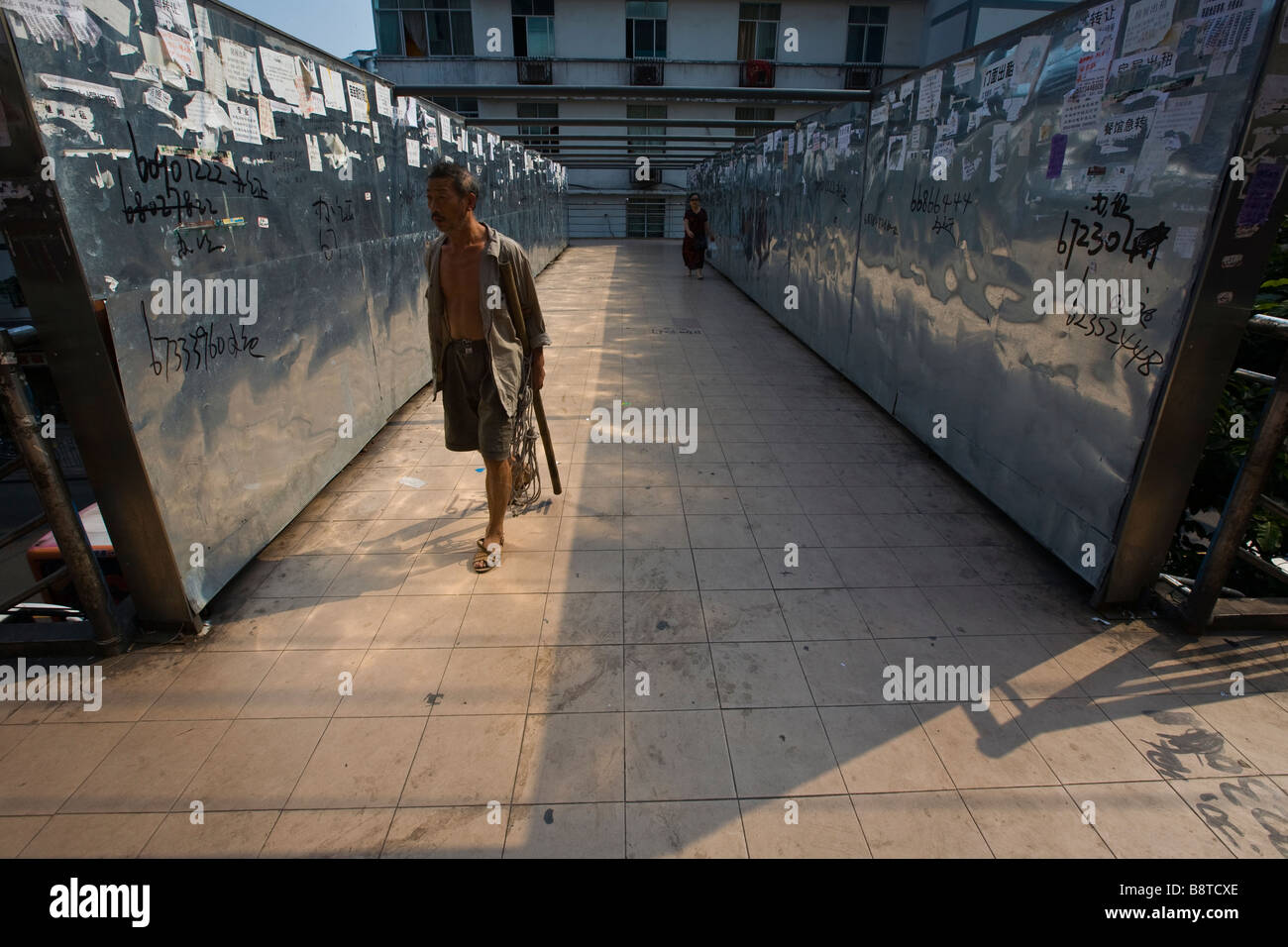 Walls of a bridge crossing in Chongqing City, China, are plastered with personal ads. Stock Photo