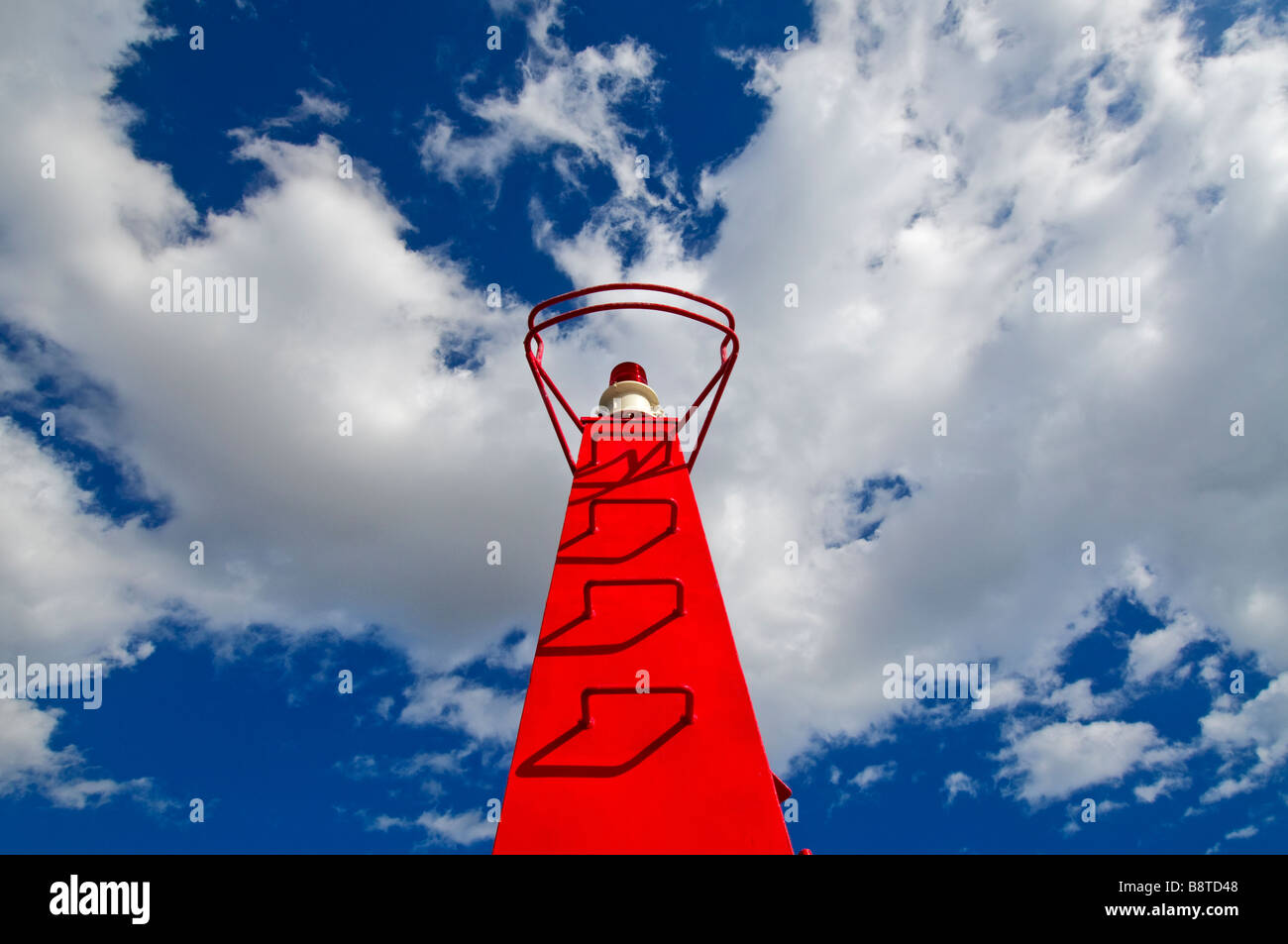 Red shipping navigation warning beacon on coastal harbour wall Stock Photo