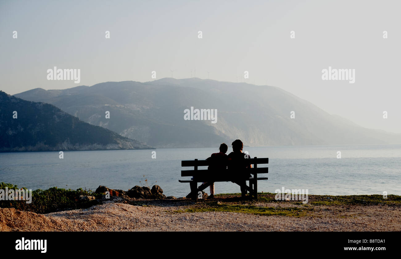Couple on bench at sunset  - Assos, Kefalonia, Greece, Europe Stock Photo