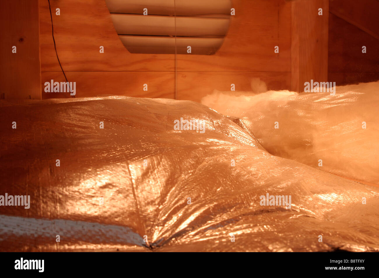 Heat reflecting aluminum foil on fibreglass loft insulation Stock Photo