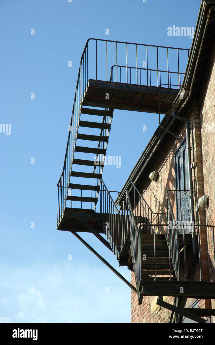 External fire escape, metal steps to roof safety against a blue sky ...