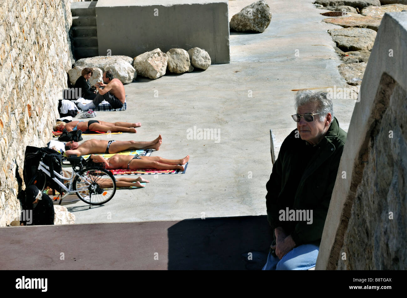 Nice, France, 'Beach Scene', Older French People Sunbathing on Sidewalk near 'Mediterranean Sea' and Port Area, 'Quai de Lunel' Stock Photo