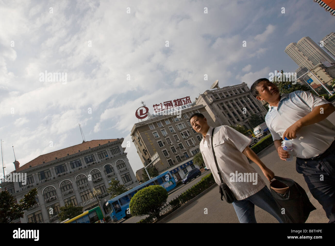 Two chinese businessmen strolling at lunch break on Yanjiang road in the central Hankou district of Wuhan, Hubei province, China Stock Photo