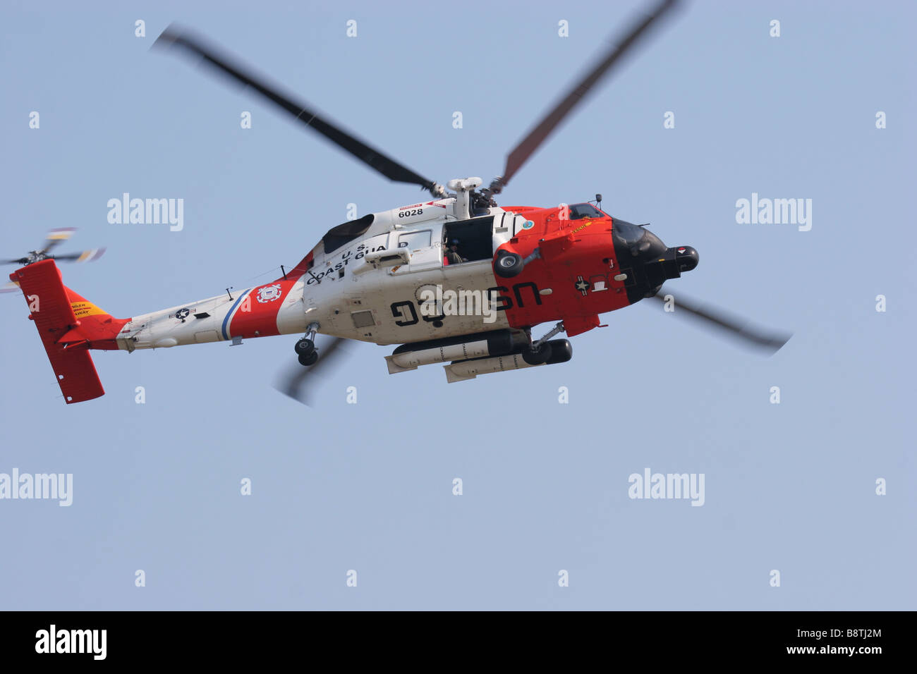 A United states Coast Guard Jayhawk helicopter flies overhead at Air Station Cape Cod in Falmouth Massachusetts Stock Photo