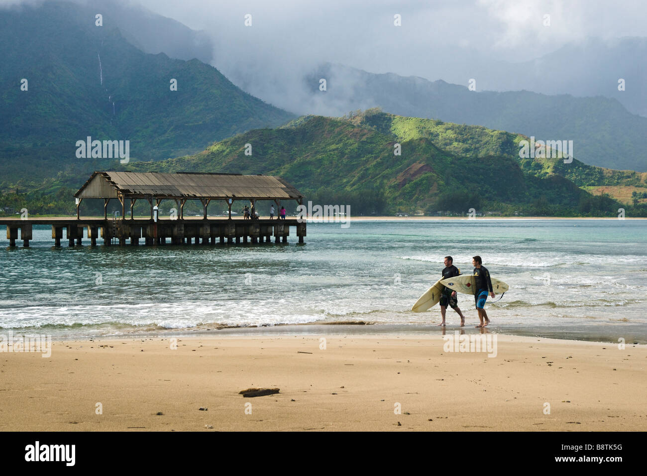 Surfer Dudes and Pier at Hanalei Bay Kauai Hawaii USA Stock Photo