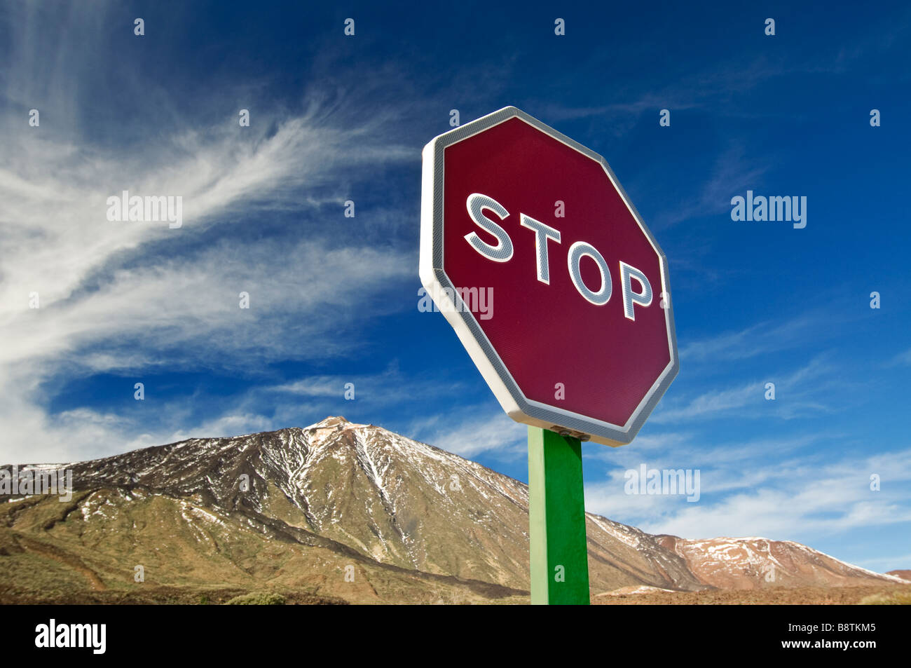 'STOP' road sign with mountain behind representing a symbolic warning for environmental issues such as global climate change Stock Photo