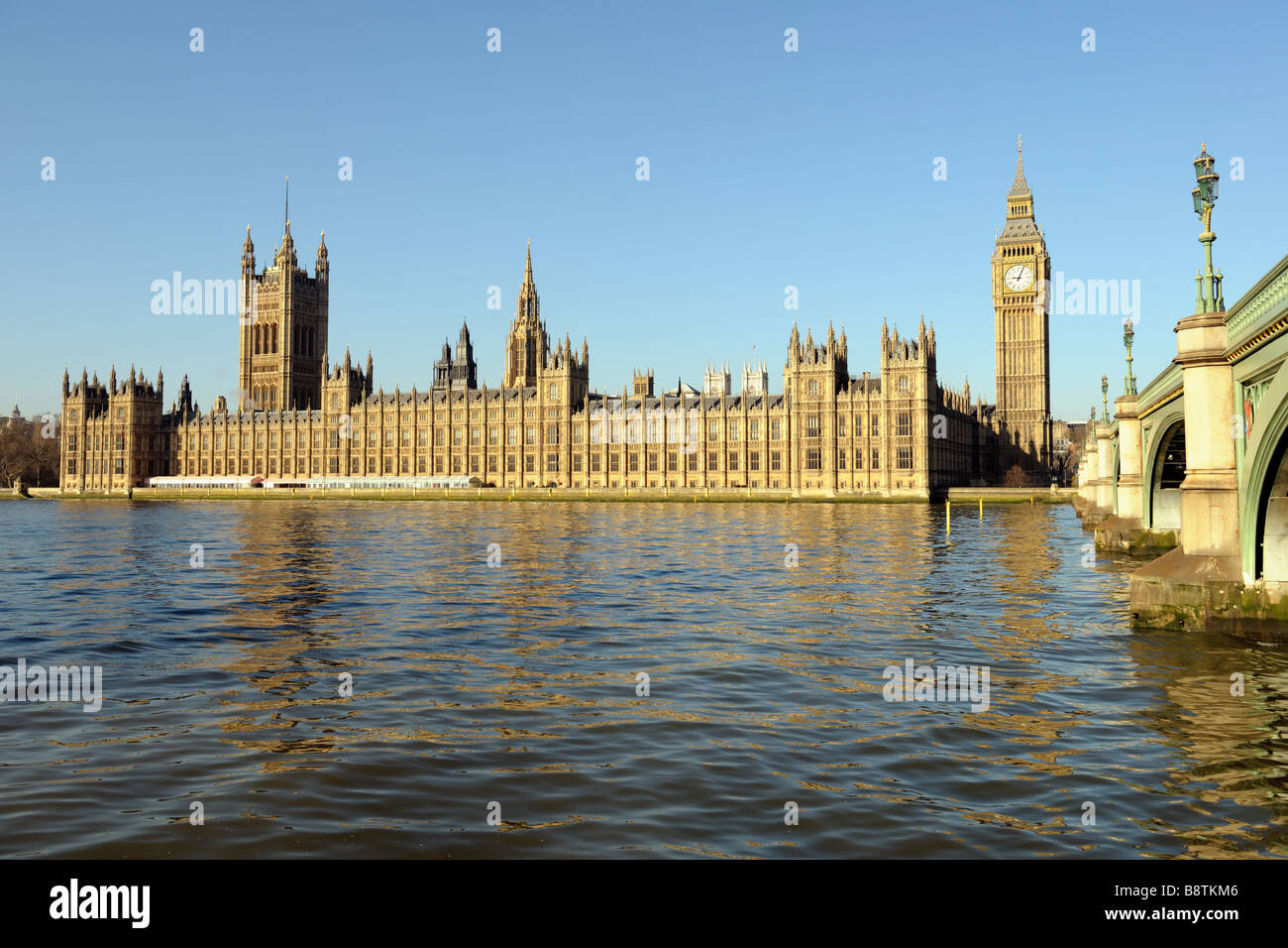 Palace of Westminster over the Thames with Big Ben and Westminster Bridge on the right in morning light and a clear blue sky Stock Photo