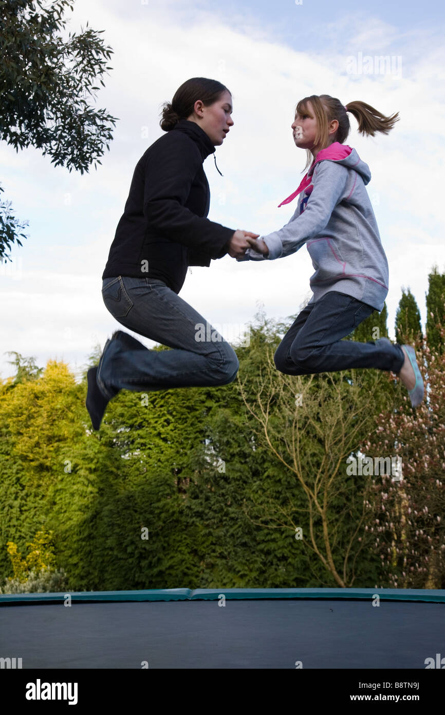 Two girls jumping on trampoline hi-res stock photography and images - Alamy