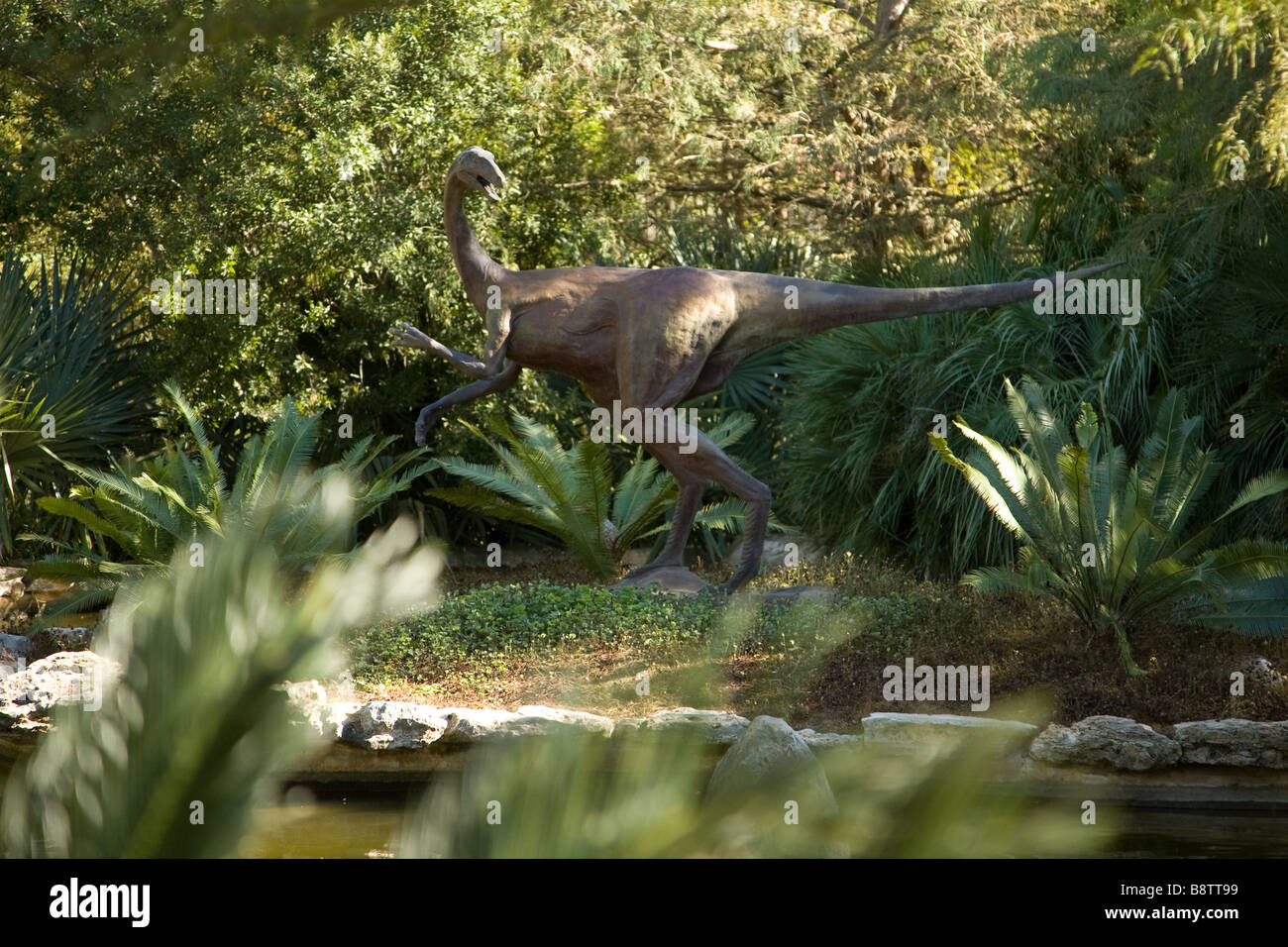 A bronze velociraptor statue in the Prehistoric Garden at the Zilker