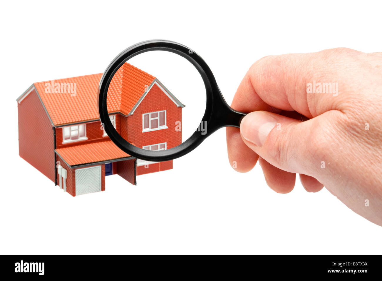 Examining a house through a magnifying glass Stock Photo