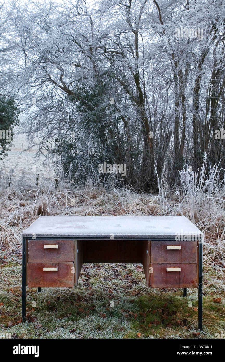 An old wooden desk that has been left outside and is covered in frost Stock Photo