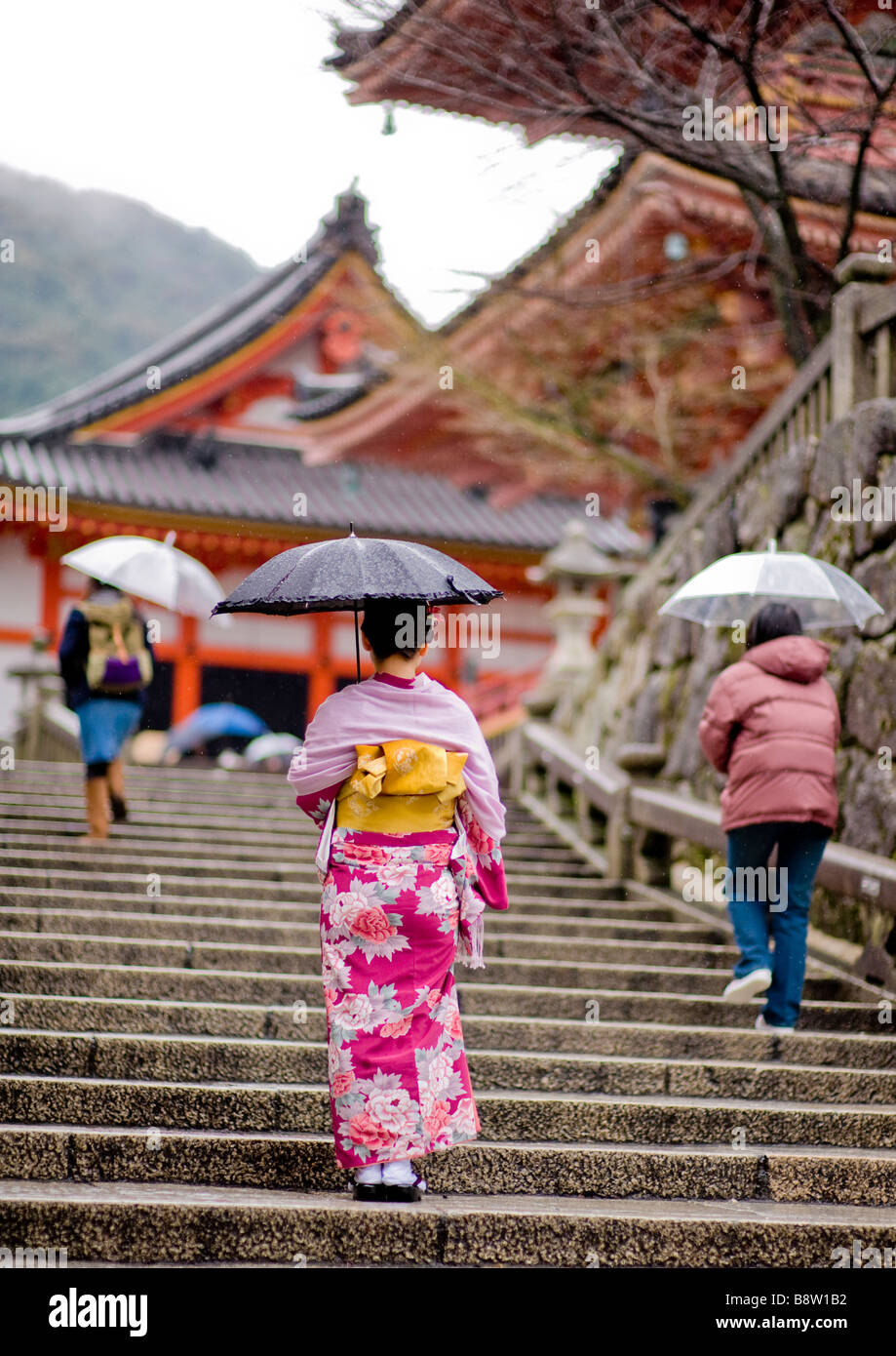 Japanese woman in a pink kimono climbs the stairs of the Kiyomizudera temple - Kyoto, Japan Stock Photo
