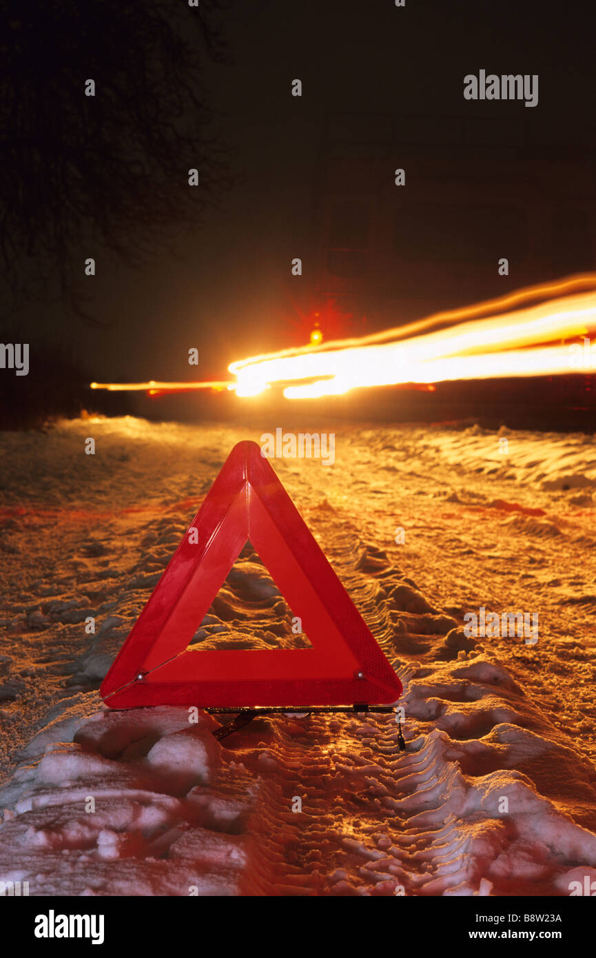 vehicle travelling down snow bound country road by hazard warning