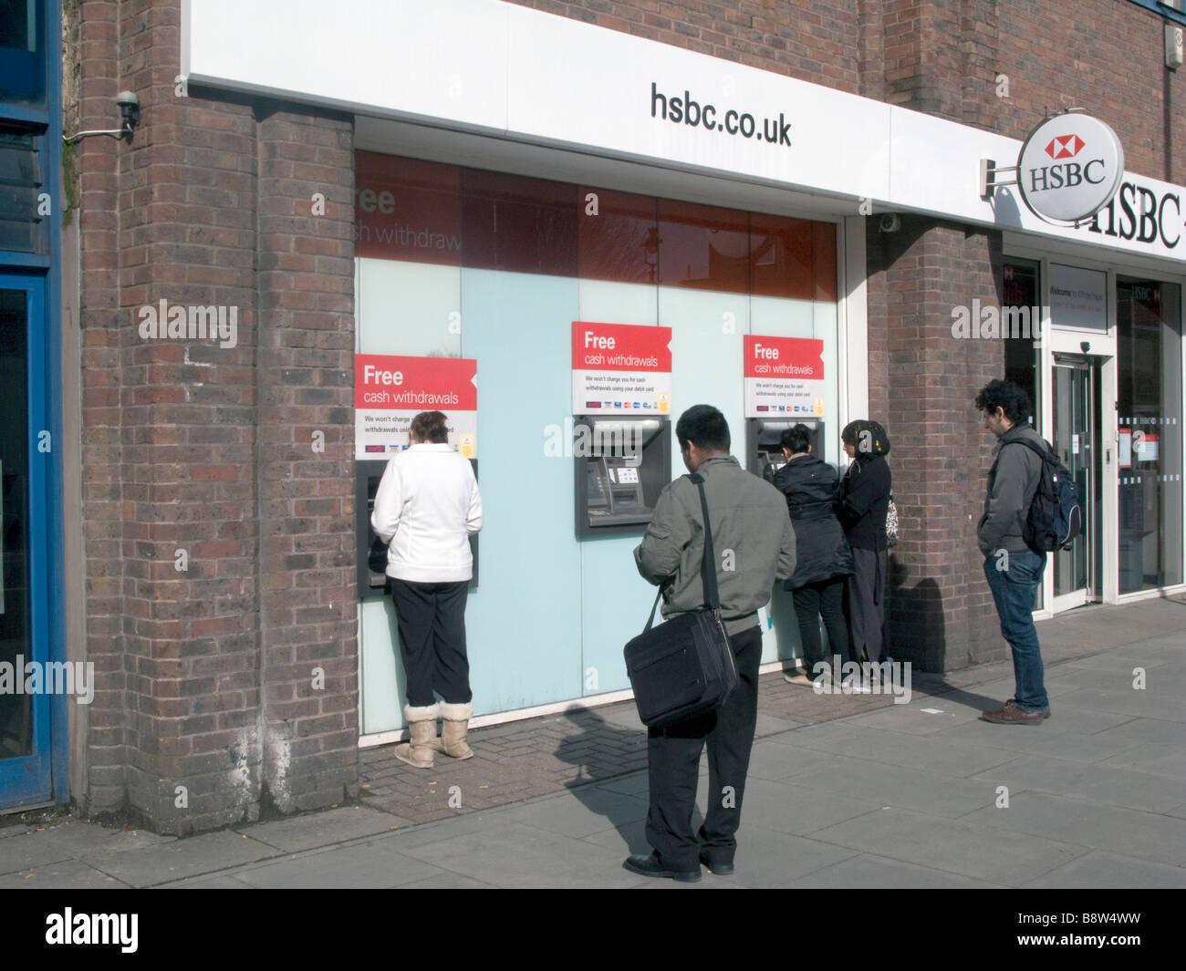UK- Customers drawing cash at ATM machine outside HSBC HQ in Whitechapel,London.Photo Julio Etchart Stock Photo