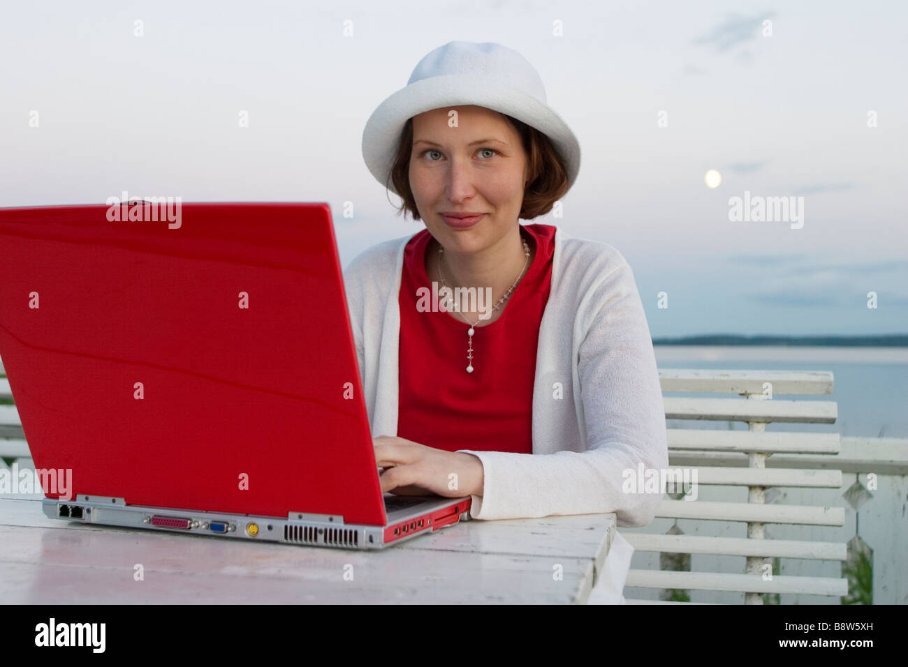 A woman using a red laptop Stock Photo - Alamy