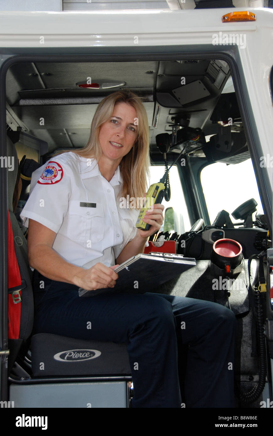 Female firefighter paramedic EMT in dress uniform looking at camera