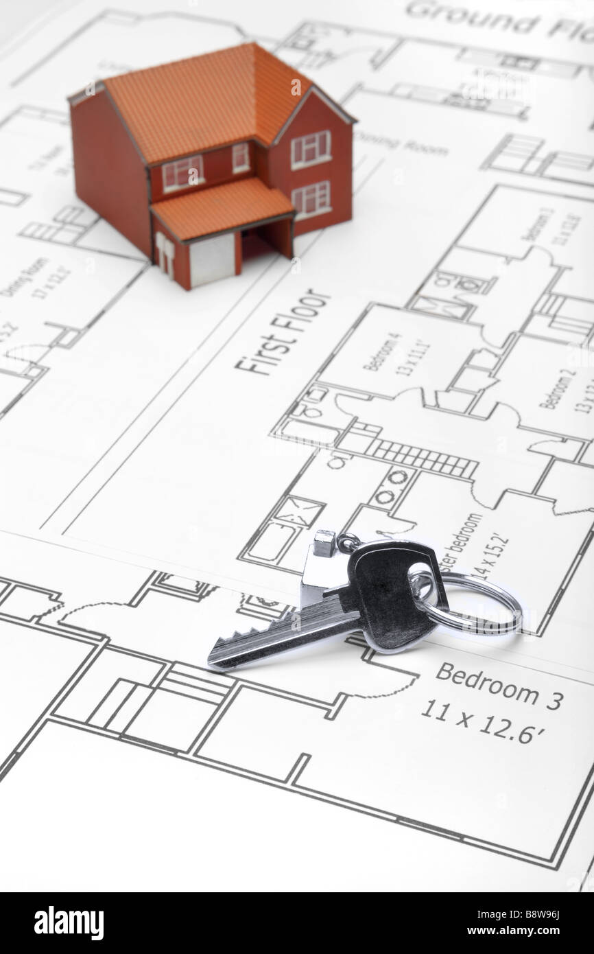 A model home and house key on architectural floor plans Stock Photo