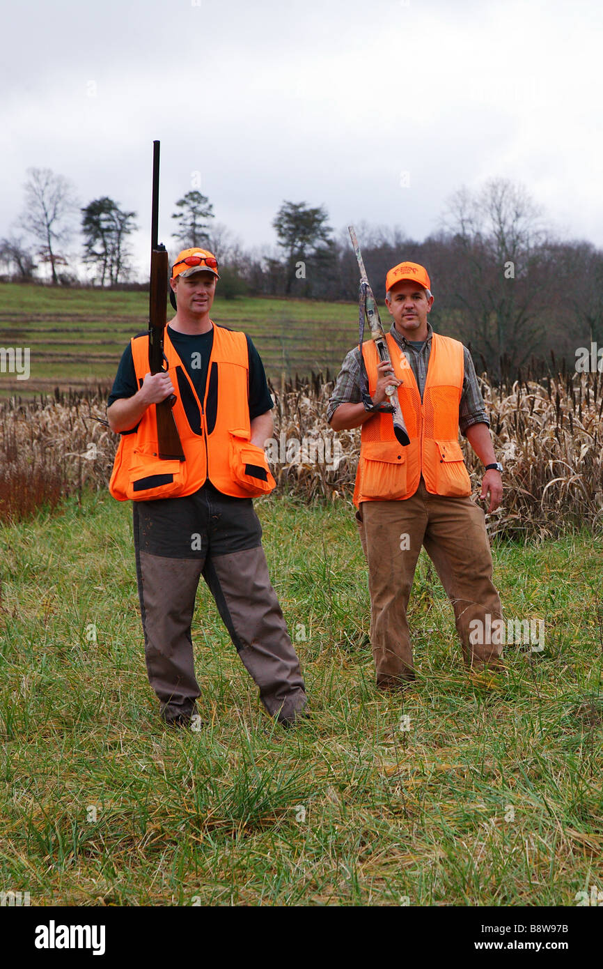 FRONT VIEW TWO UPLAND BIRD HUNTERS HOLDING GUNS ON SHOULDERS GEORGIA Stock Photo