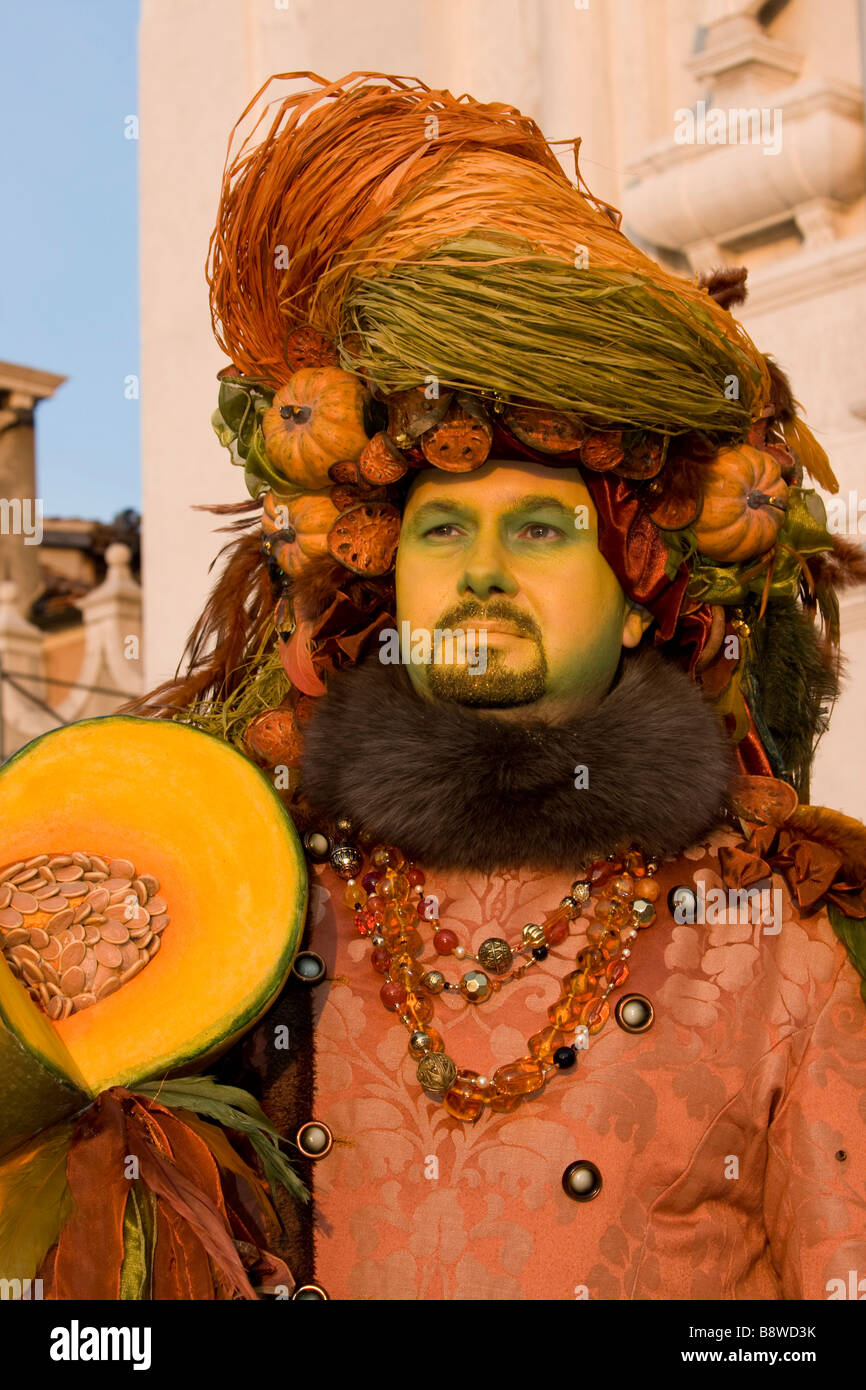 Venice Carnival. Man orange pumkin fruits hat Costume & mask, sunset