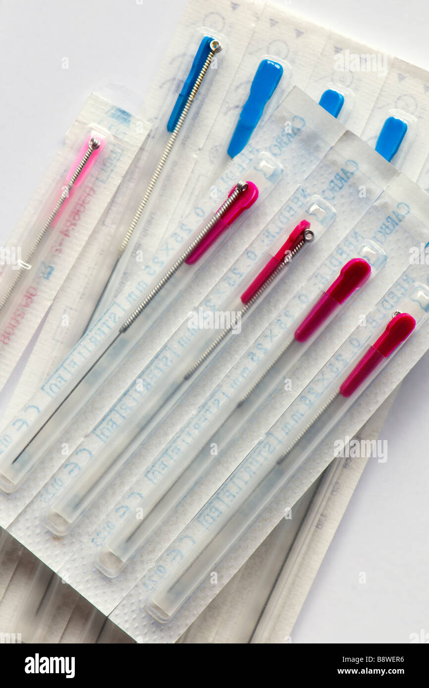 Assortment of different sized sealed acupuncture needles in packets taken against a plain white background Stock Photo
