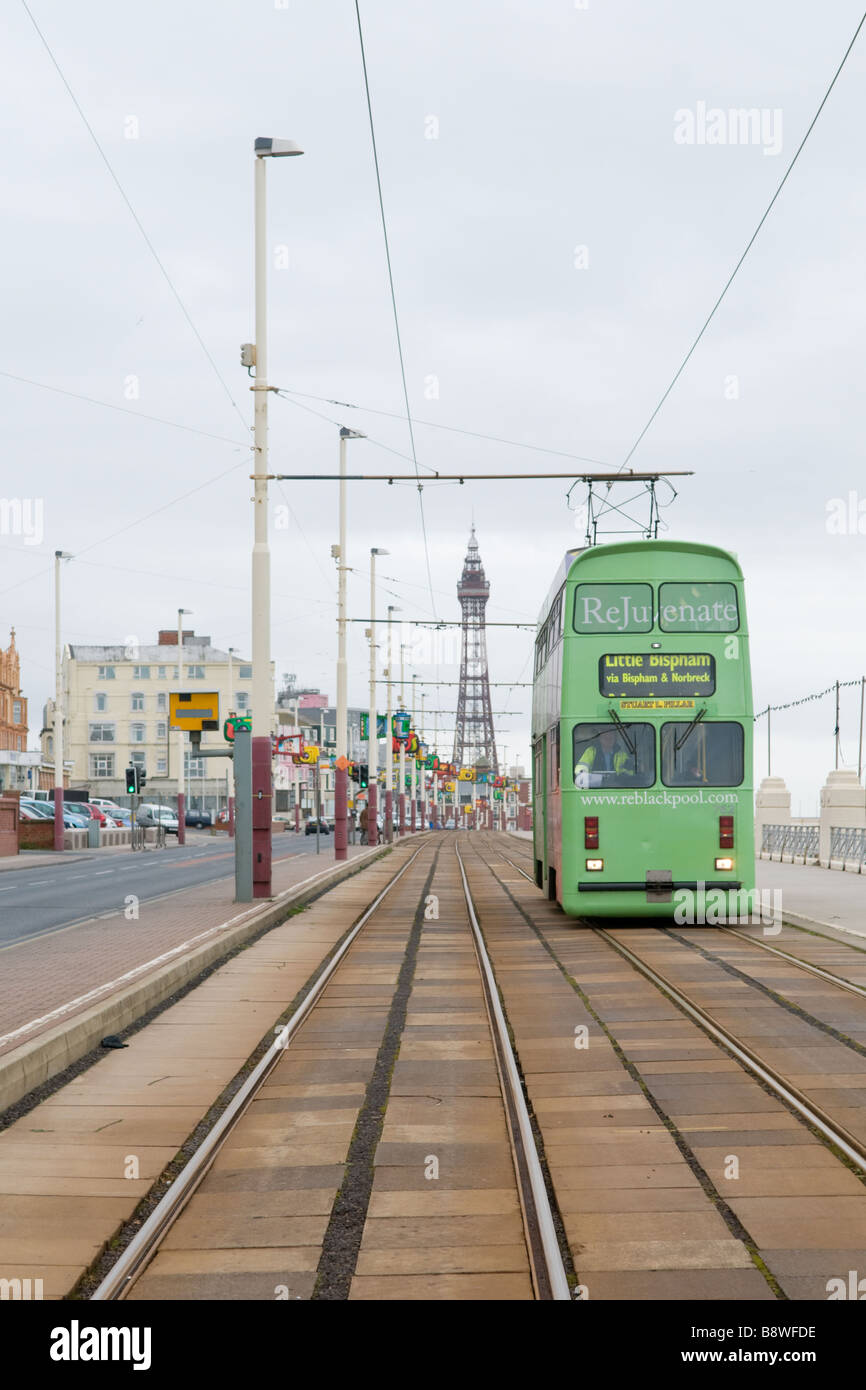 A tram heading for Bispham approaches a stop on North Promenade in Blackpool, England, with Blackpool Tower in the background Stock Photo