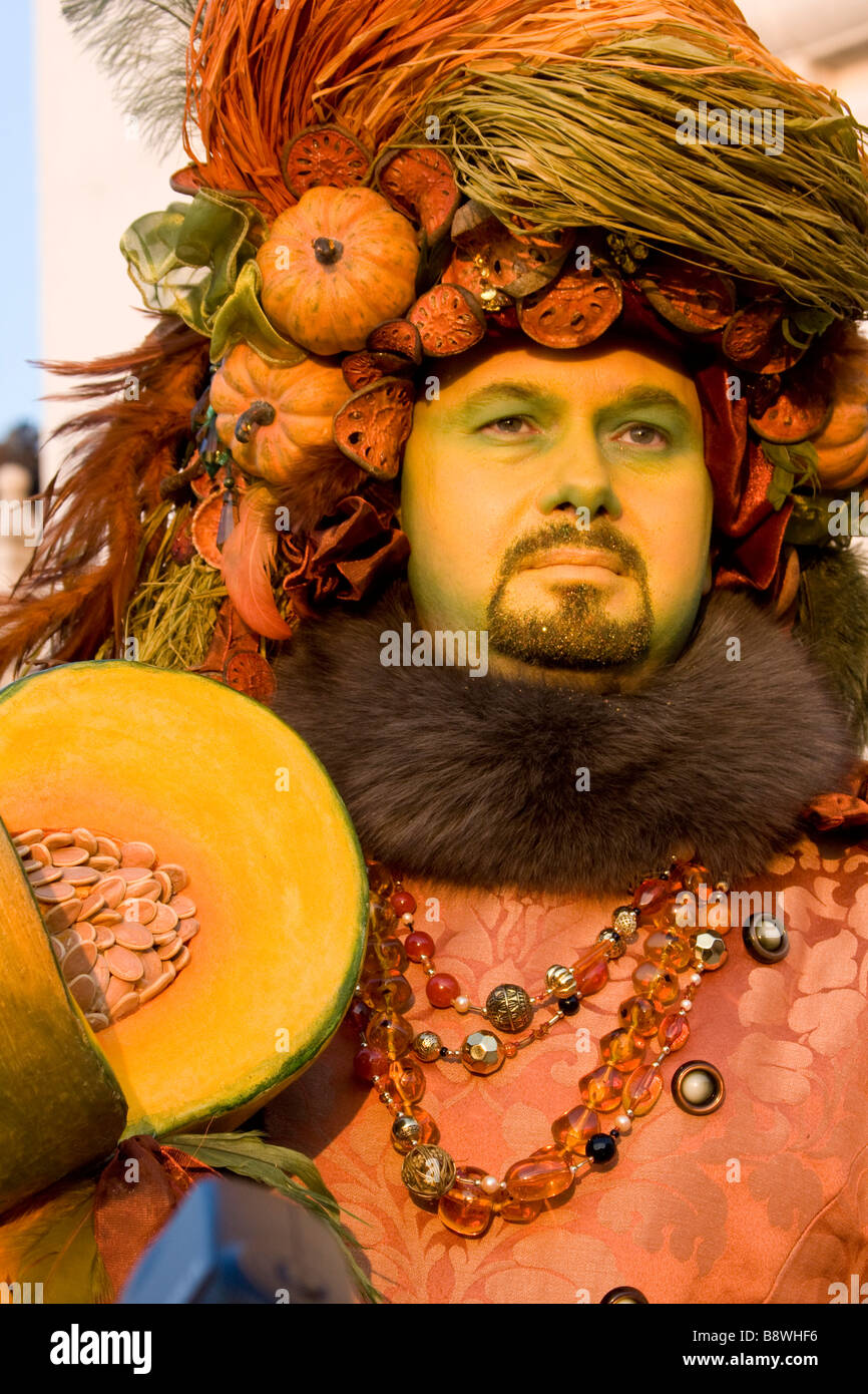 Venice Carnival. Man orange pumkin fruits hat Costume & mask, sunset