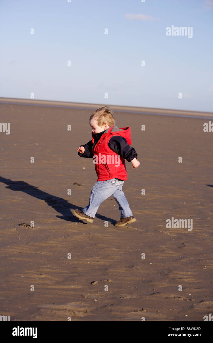 little boy in red jacket running on a beach Stock Photo Alamy