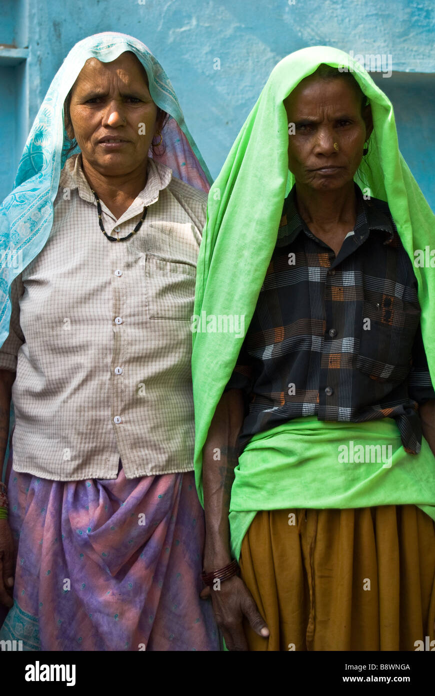 Two elderly village woman standing outside their home in a traditional suburban Indian village Stock Photo