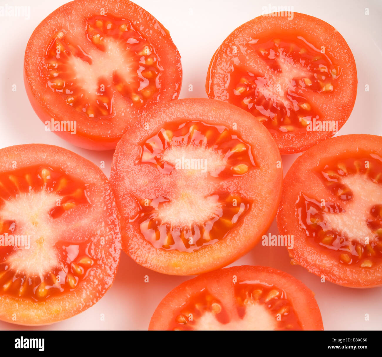 A close up shot of a cross section of several fresh red tomatoes Stock Photo