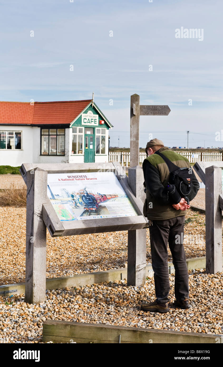 A male adult man looking at the directions on a notice board outside a cafe at Dungeness in Kent, UK. Stock Photo